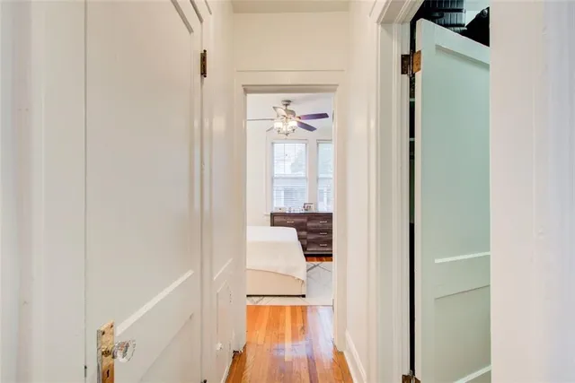 a view of a hallway with wooden floor and a living room