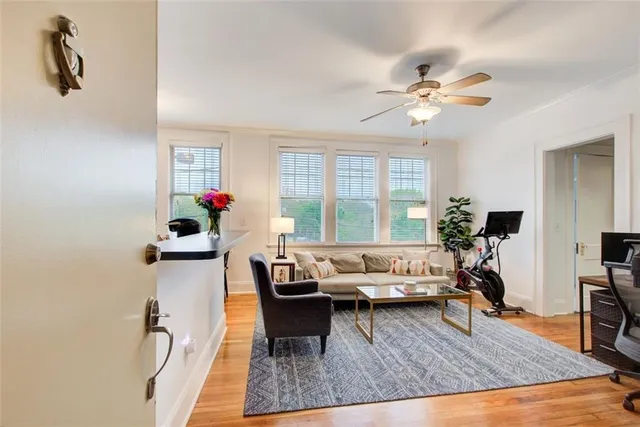 a living room with furniture gym equipment and a large window