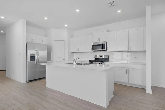 a view of kitchen with granite countertop cabinets and refrigerator