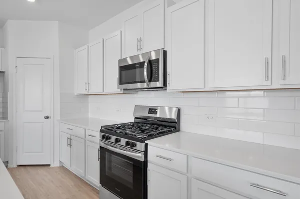 a kitchen with stainless steel appliances granite countertop a sink stove and cabinets