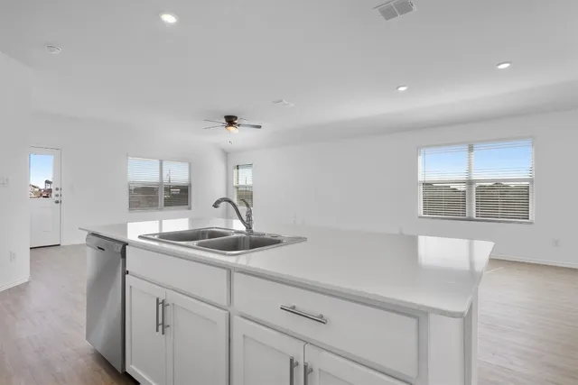 a kitchen with white cabinets and appliances