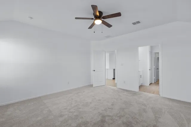 a view of a room with a ceiling fan and a window