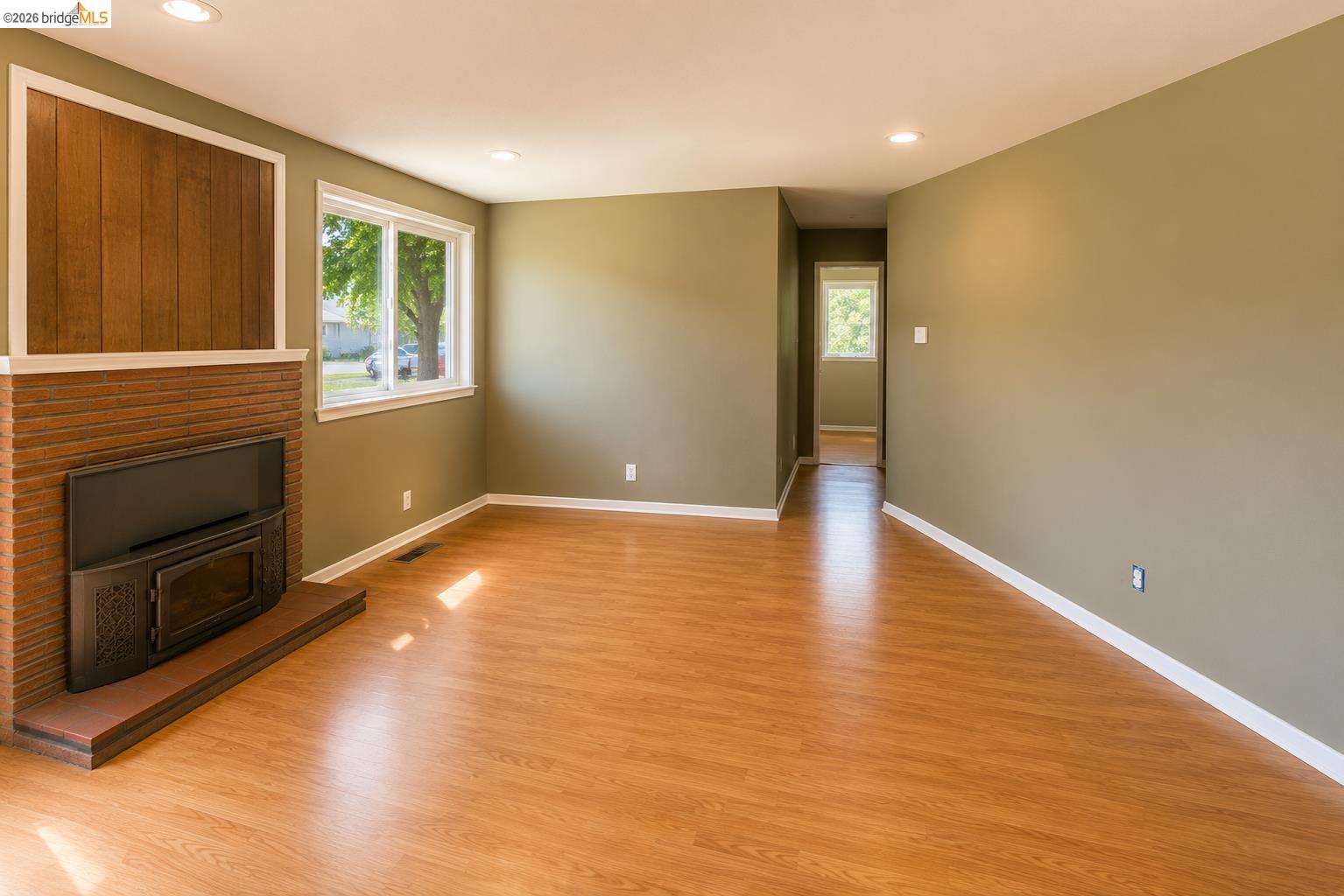 269 Crescent Drive Rio Vista, CA 94571 - Photo 2 of 9 Spacious living area featuring wood-finish flooring, recessed lighting, and a brick-faced fireplace with a wood-paneled accent wall