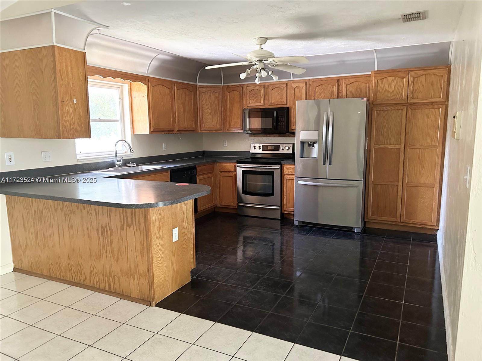 9227 Highway 80 Moore Haven, FL 33471 - Photo 12 of 20 a kitchen with stainless steel appliances a sink cabinets and a counter top space