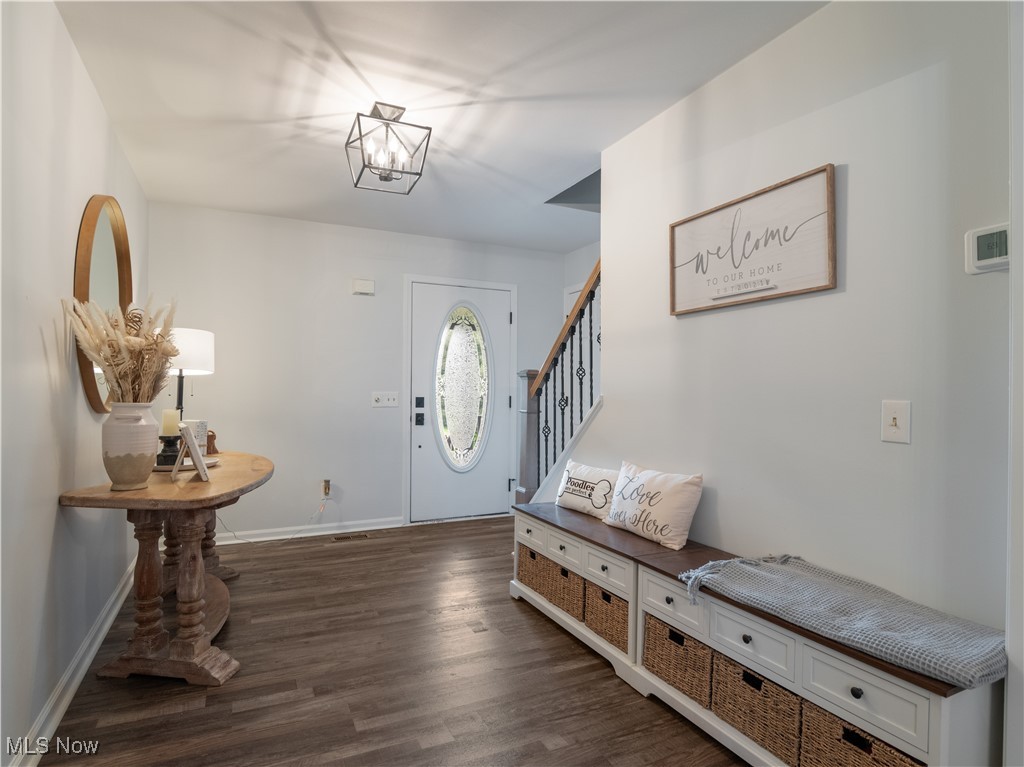 426 Bostic Road Gallipolis, OH 45631 - Photo 9 of 45 Foyer entrance with dark wood finished floors, stairs, baseboards, and a chandelier