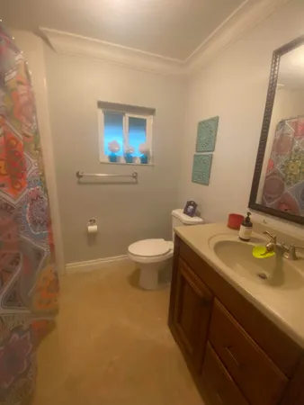 a bathroom with a granite countertop sink a large mirror and a toilet