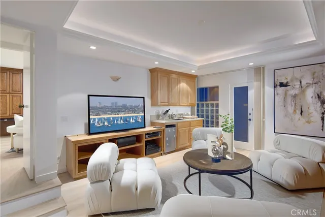 a living room with furniture kitchen view and a window