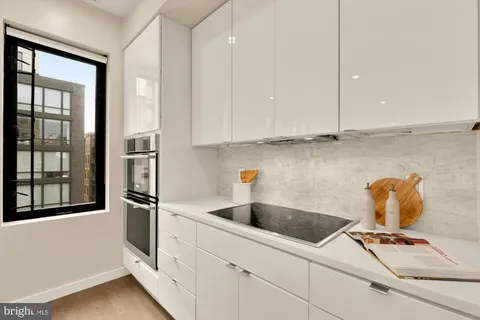a kitchen with stainless steel appliances a sink a refrigerator and cabinets