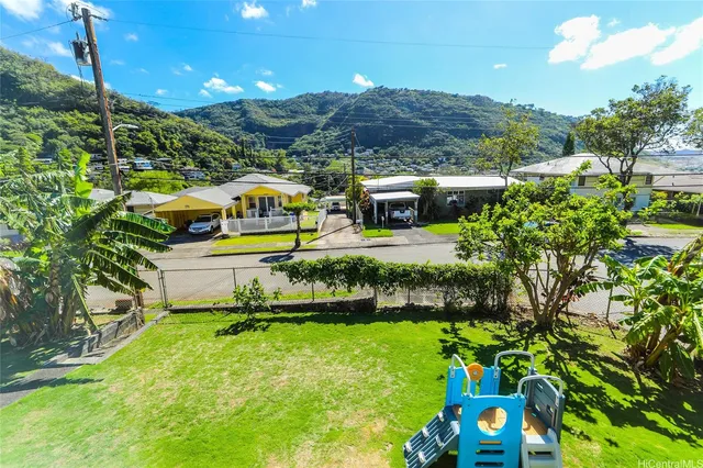 a front view of house with a yard and mountain view