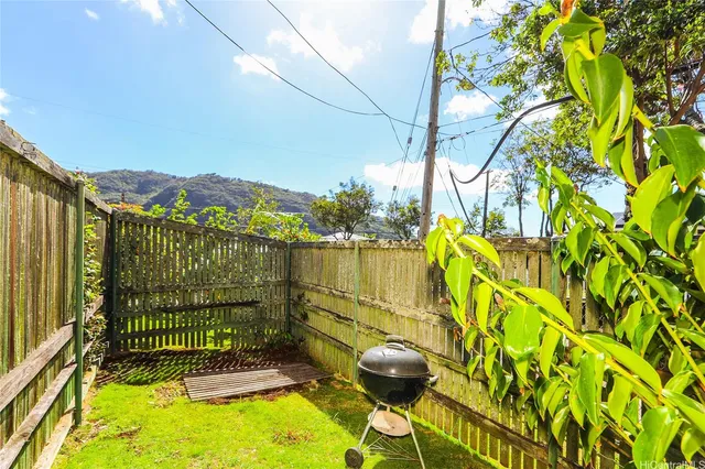a backyard of a house with table and chairs a fire pit