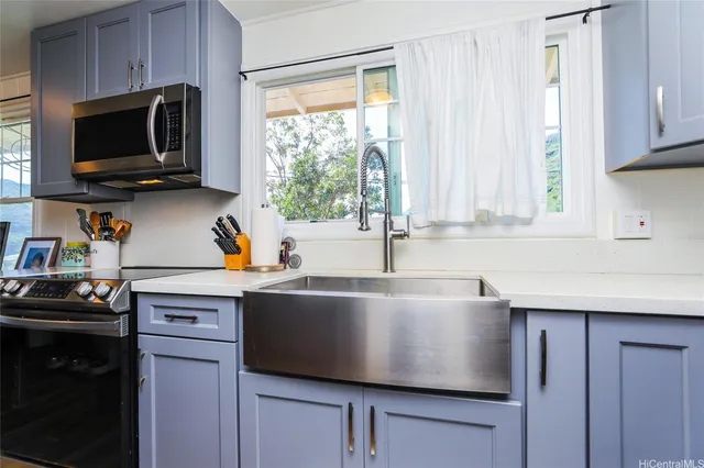 a kitchen with stainless steel appliances a stove microwave and sink