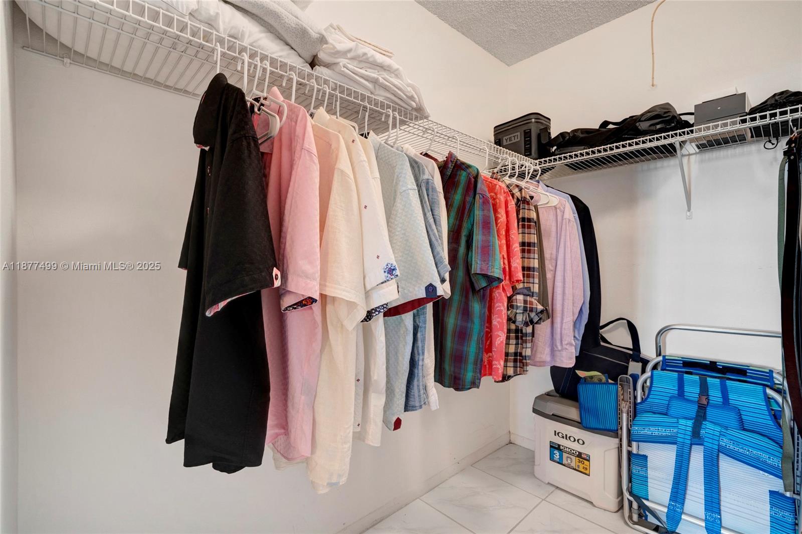 500 Three Islands Boulevard, Unit 320 Hallandale Beach, FL 33009 - Photo 11 of 27 a view of walk in closet with clothes and shoes