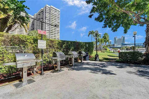 a view of a tennis ground with large trees