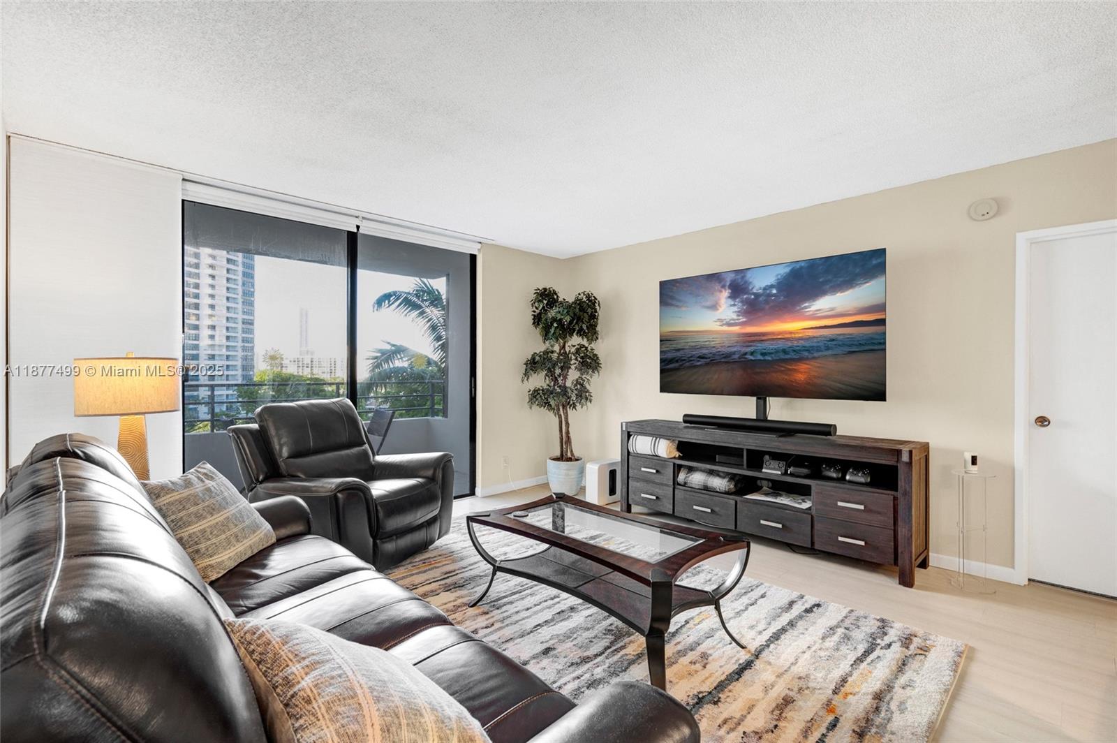 500 Three Islands Boulevard, Unit 320 Hallandale Beach, FL 33009 - Photo 5 of 27 a living room with furniture and a flat screen tv