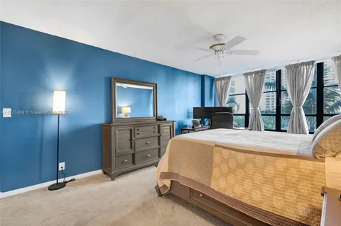 a bedroom with a bed dresser and a large window