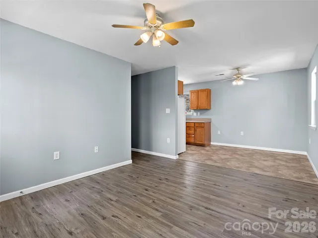 a kitchen with stainless steel appliances granite countertop a refrigerator a stove a sink a dining table and chairs with wooden floor