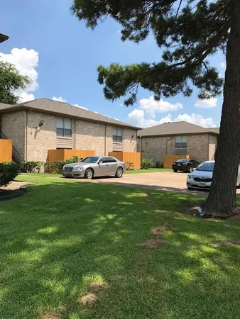 a row of car parked in front of yellow house