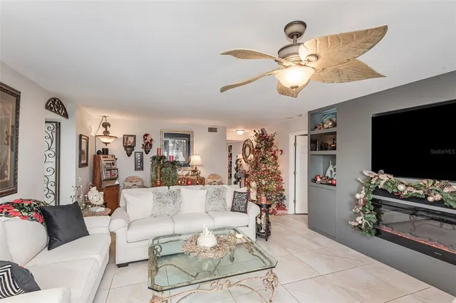 a living room with stainless steel appliances kitchen island granite countertop a dining table chairs and a sink