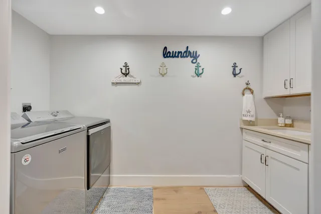 a kitchen with stainless steel appliances kitchen island granite countertop a stove a sink a refrigerator and a living room view