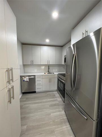 488 Fanshaw L, Unit 488 Boca Raton, FL 33434 - Photo 2 of 10 a kitchen with stainless steel appliances a refrigerator sink and cabinets