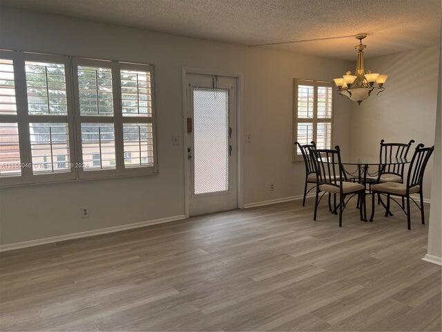 488 Fanshaw L, Unit 488 Boca Raton, FL 33434 - Photo 4 of 10 an empty room with wooden floor and windows