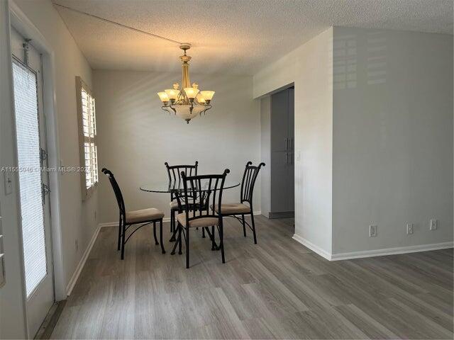 488 Fanshaw L, Unit 488 Boca Raton, FL 33434 - Photo 6 of 10 a view of a dining room with furniture and wooden floor