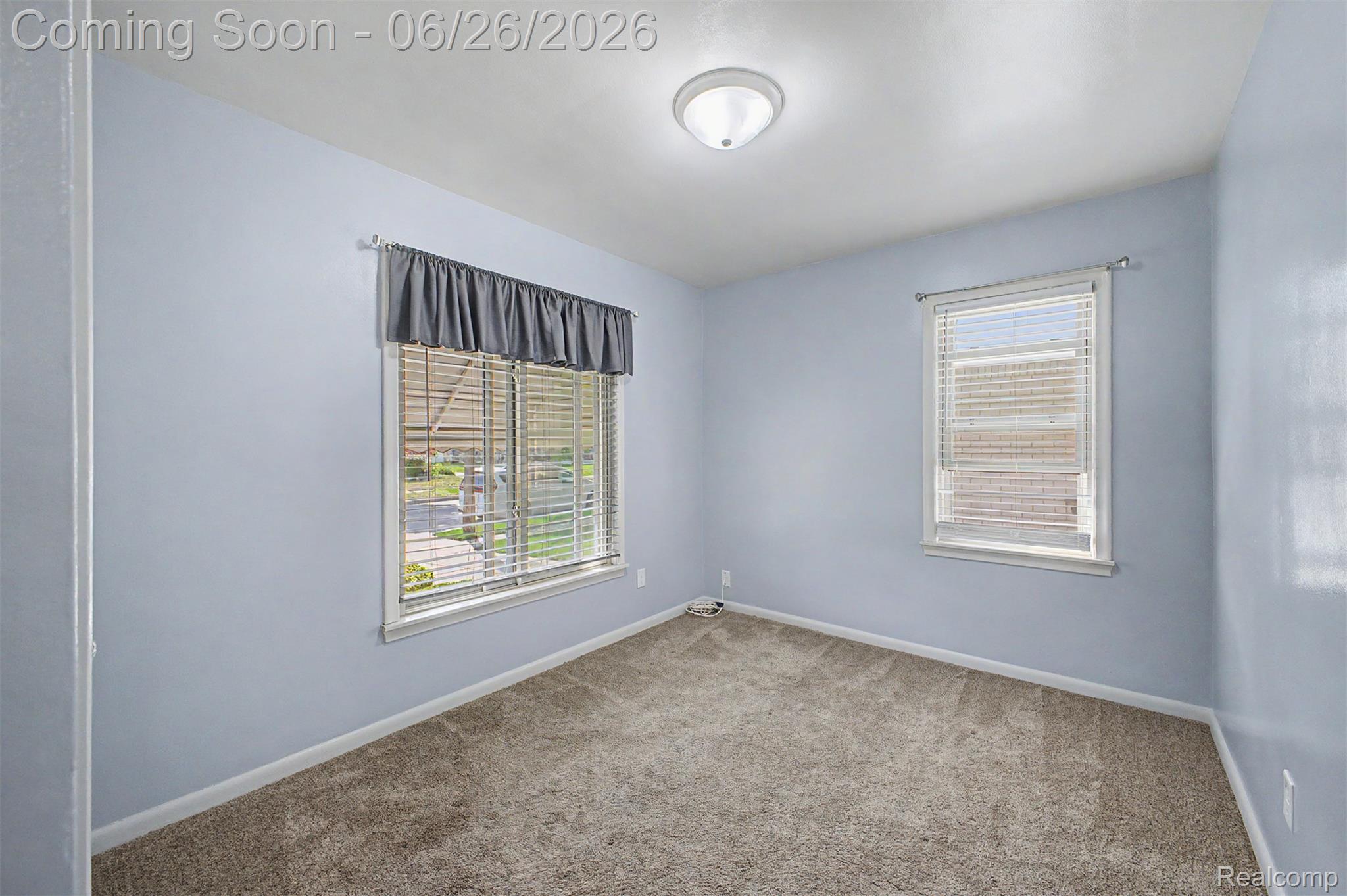 2216 Banner Street Dearborn, MI 48124 - Photo 8 of 34 Room featuring light blue walls, two windows with blinds, and beige carpeting