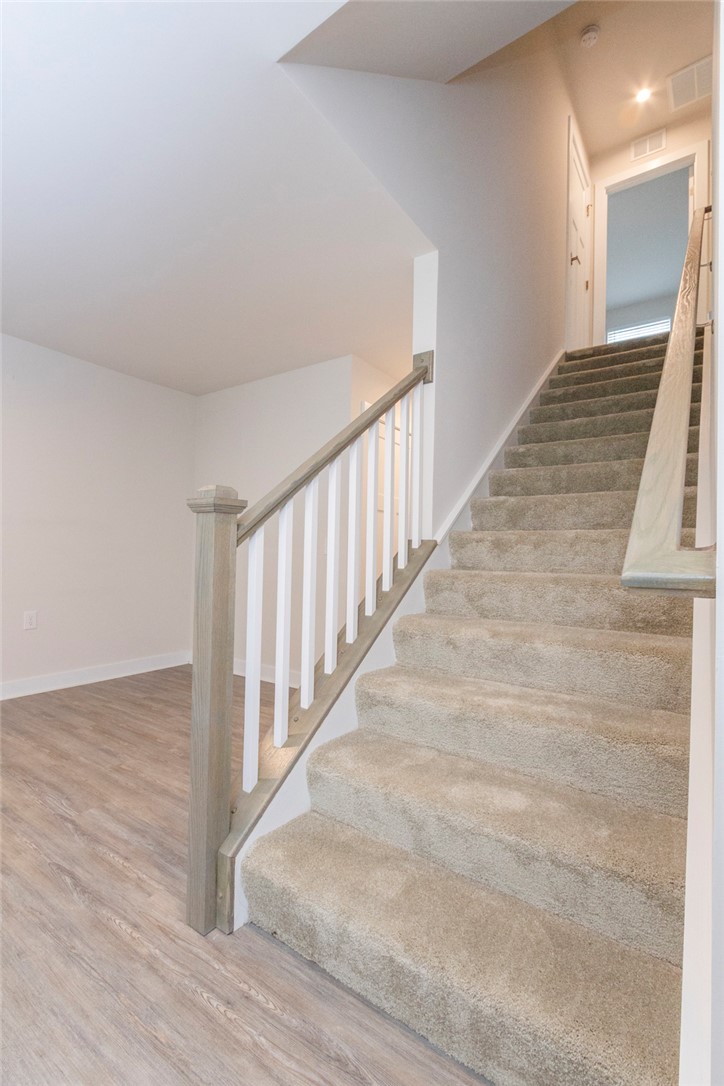 233 Scenic Road Anderson, SC 29621 - Photo 23 of 50 A well-lit entryway features a carpeted staircase with light wood and white railing.