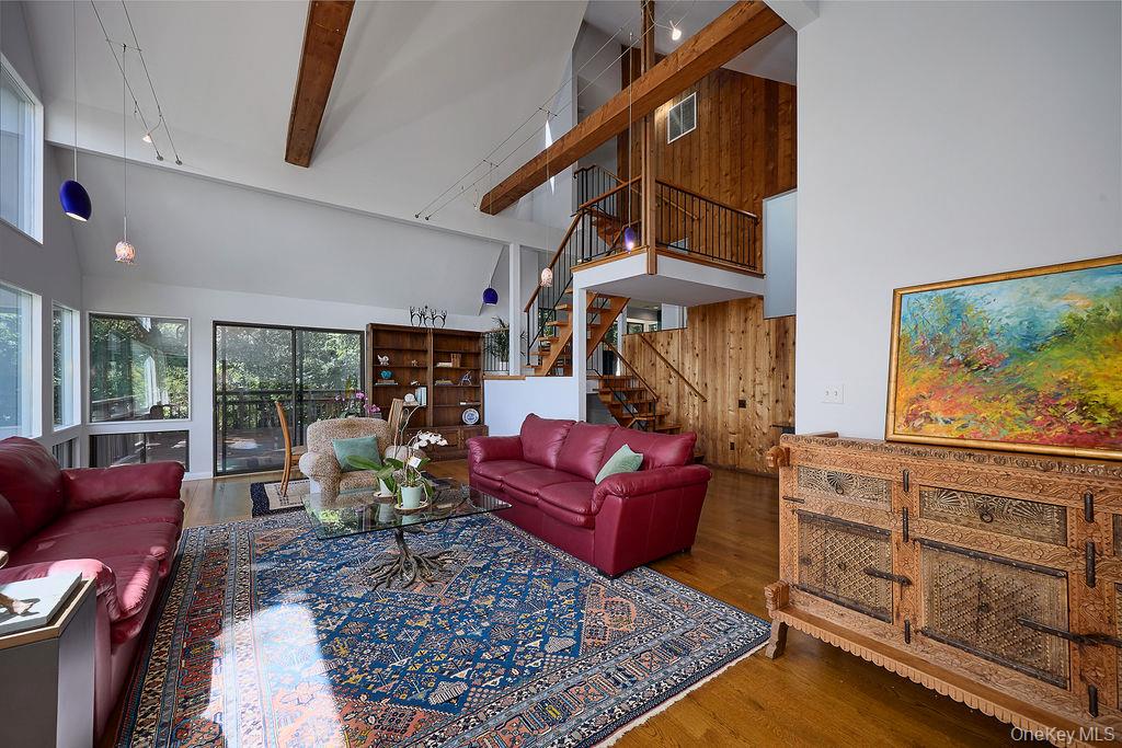 273 River Road Nyack, NY 10960 - Photo 8 of 48 Spacious living area featuring a vaulted ceiling with exposed wood beams, hardwood flooring, and abundant natural light from multiple windows
