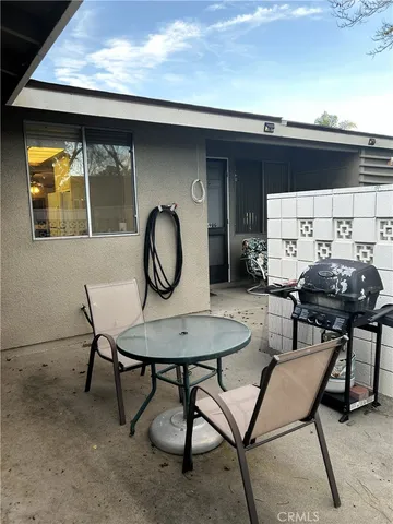 a backyard of a house with barbeque oven table and chairs