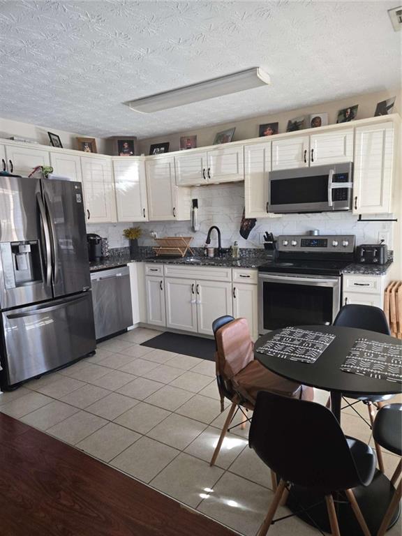 125 Sampson Court Covington, GA 30016 - Photo 4 of 13 a kitchen with stainless steel appliances a stove a sink a microwave a refrigerator and cabinets