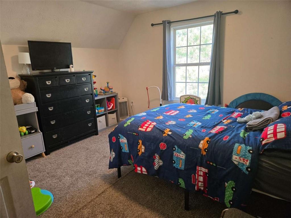 125 Sampson Court Covington, GA 30016 - Photo 9 of 13 a bedroom with a bed and a flat tv screen on dresser