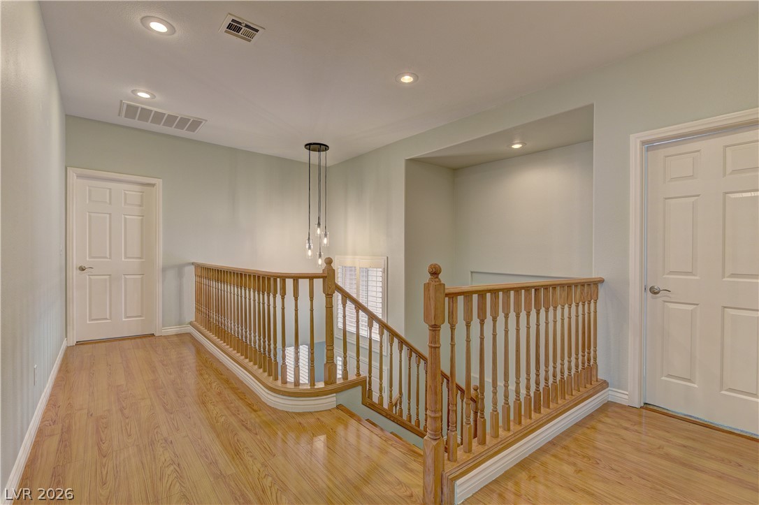 1813 Snow Spring Lane Las Vegas, NV 89134 - Photo 21 of 37 Natural light illuminates rich hardwood flooring leading to a beautifully crafted wooden staircase.