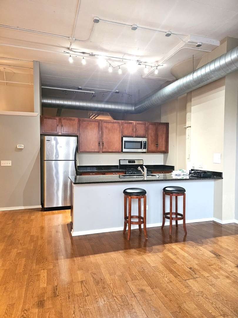 2323 West Pershing Road, Unit 128 Chicago, IL 60609 - Photo 6 of 9 a view of kitchen with refrigerator microwave and stove