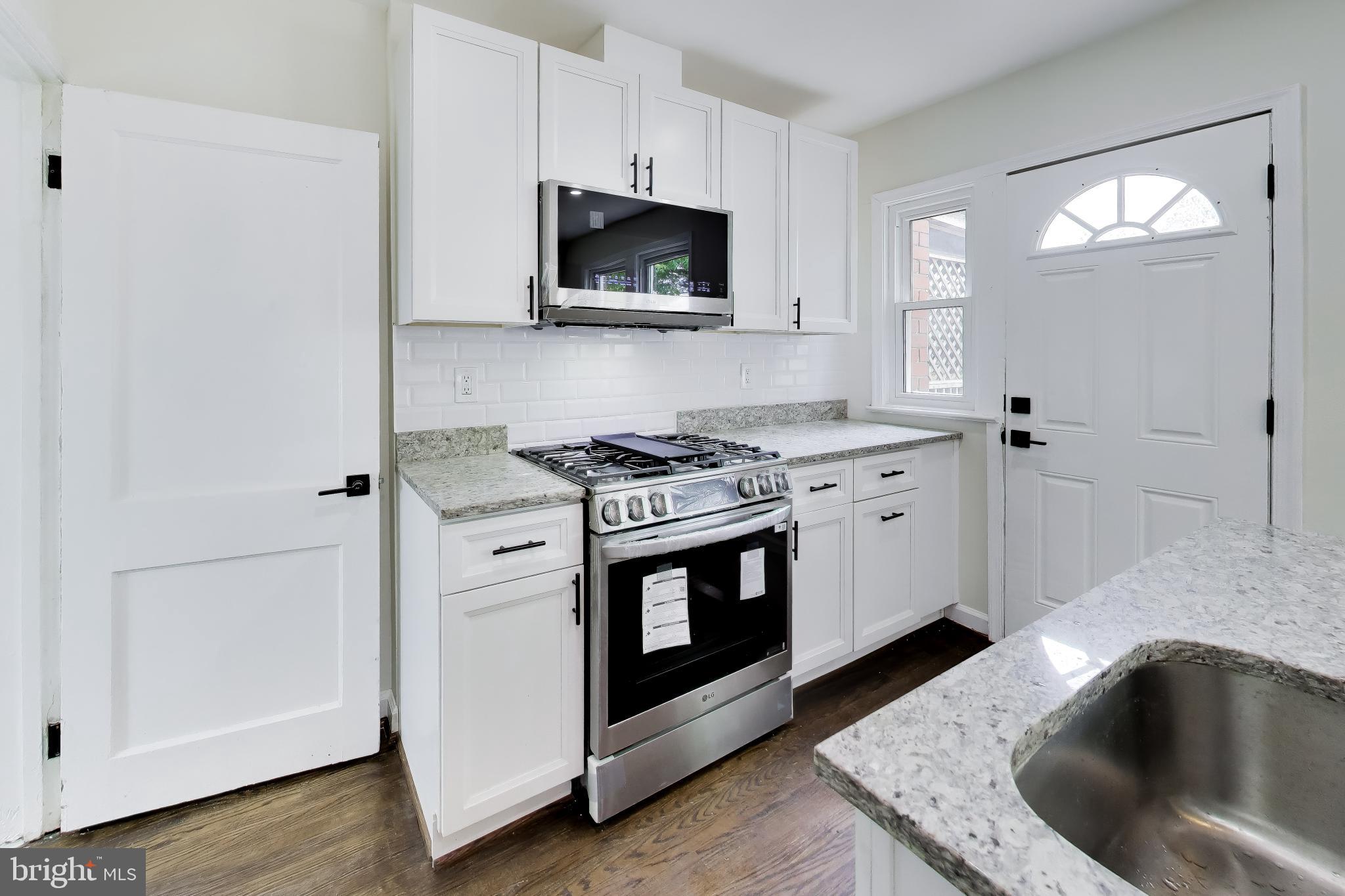 186 Forrester Street Southwest Washington, DC 20032 - Photo 12 of 32 a kitchen with granite countertop a sink and a stove top oven