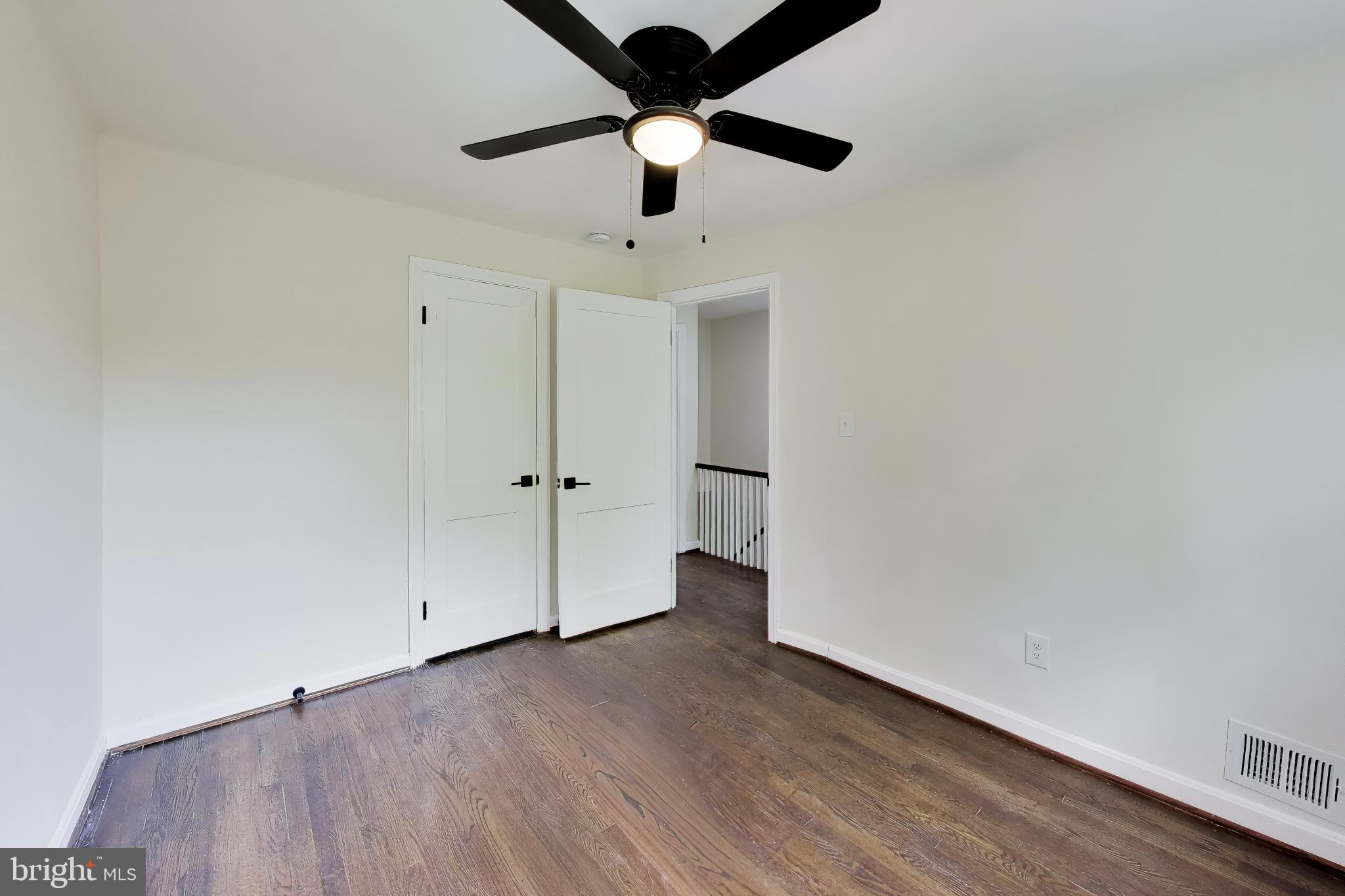 186 Forrester Street Southwest Washington, DC 20032 - Photo 19 of 32 an empty room with a ceiling fan and wooden floor