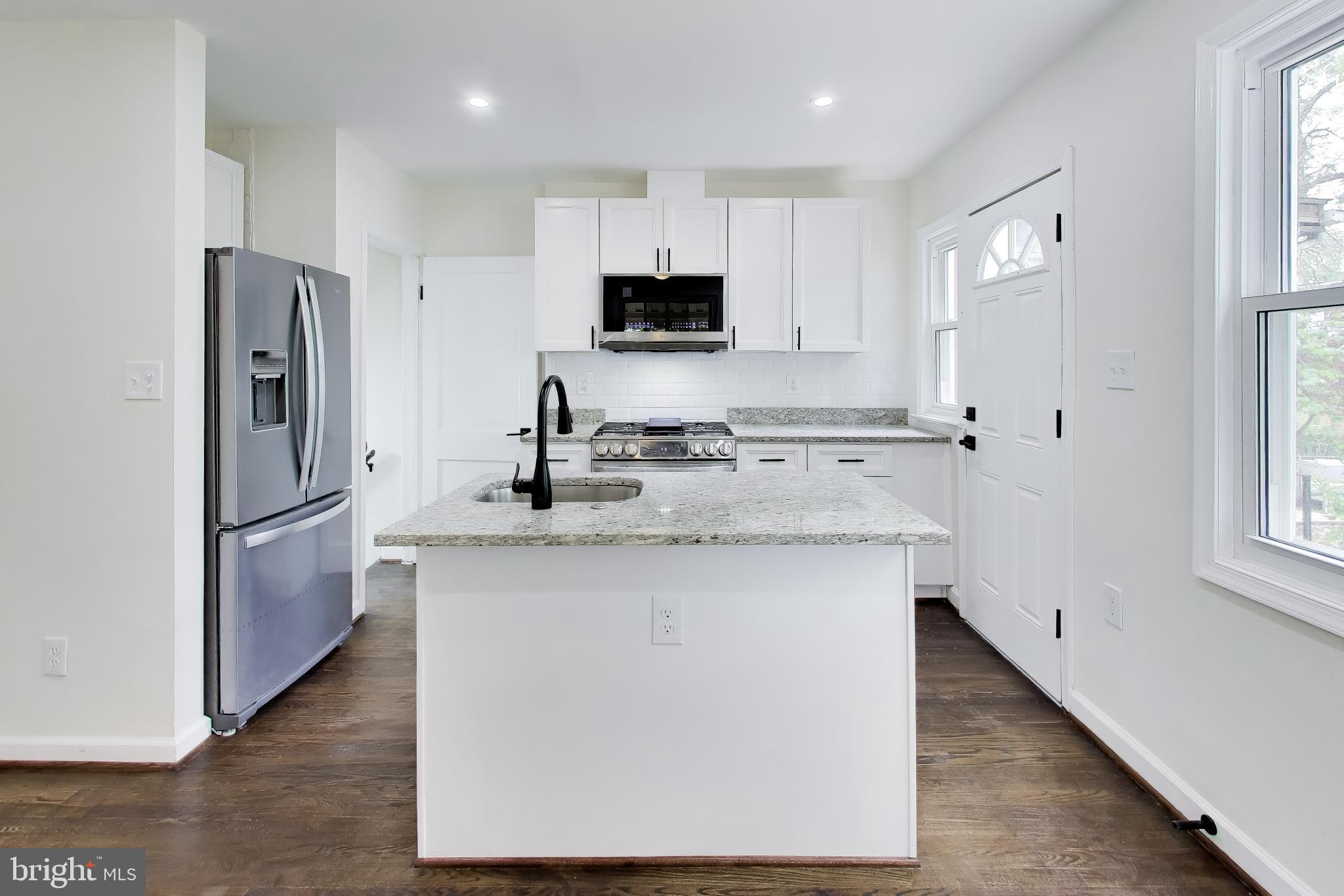186 Forrester Street Southwest Washington, DC 20032 - Photo 10 of 32 a kitchen with stainless steel appliances granite countertop a stove a refrigerator a sink a microwave and island