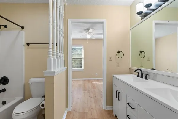 an empty room with wooden floor and ceiling fan