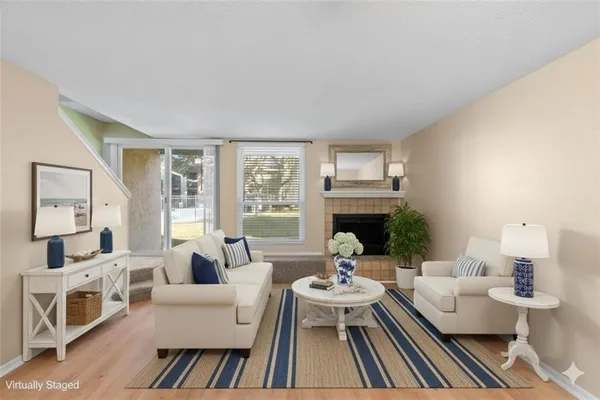 a living room with furniture fireplace and a large window