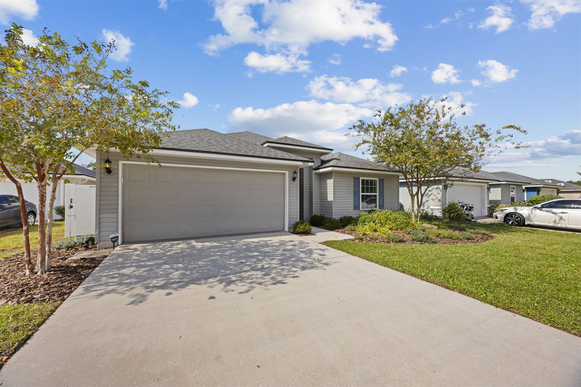 94037 Last Lane Yulee, FL 32097 - Photo 3 of 38 a front view of a house with a yard and garage