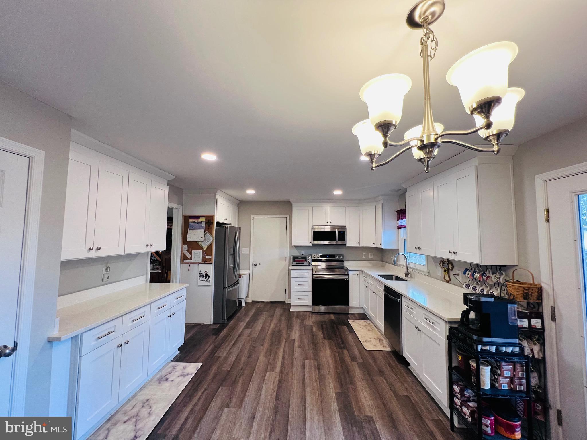 436 Thompson Circle Colonial Beach, VA 22443 - Photo 15 of 40 a large kitchen with cabinets wooden floor and stainless steel appliances