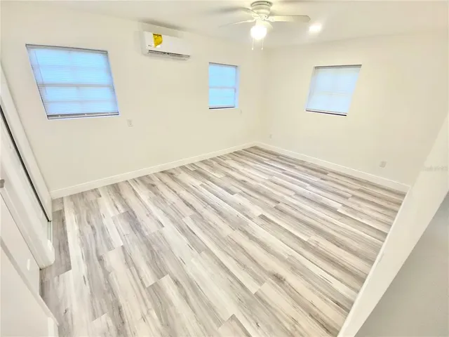 a view of a room with wooden floor and a ceiling fan