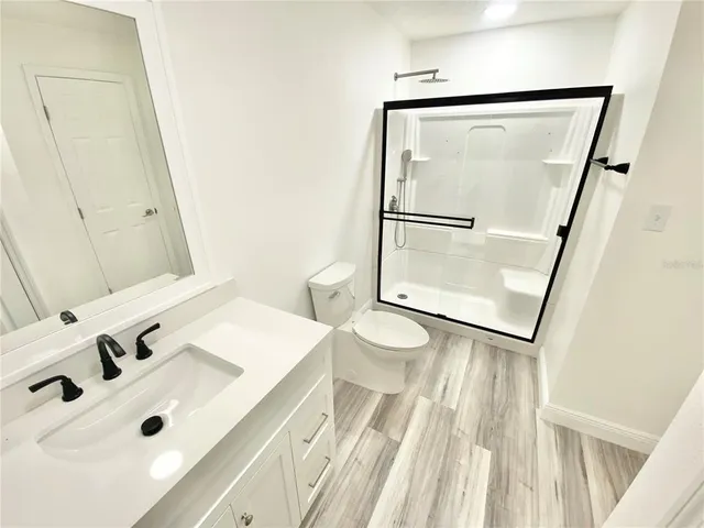 a bathroom with a sink mirror vanity and toilet