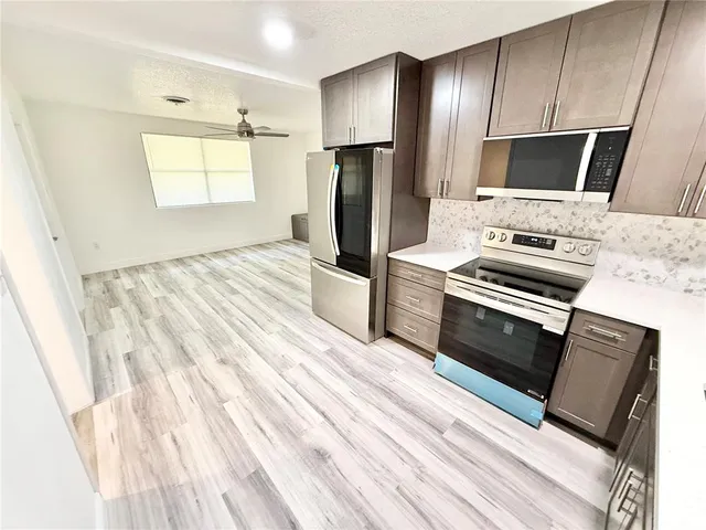a kitchen with a refrigerator stove and microwave