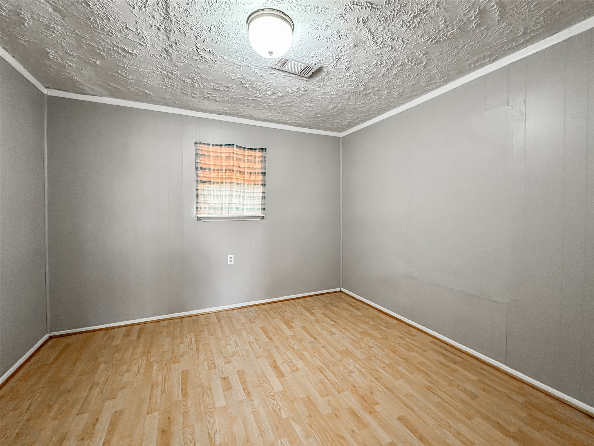 132 Grothe Lane Houston, TX 77022 - Photo 26 of 36 a view of an empty room with wooden floor and a window