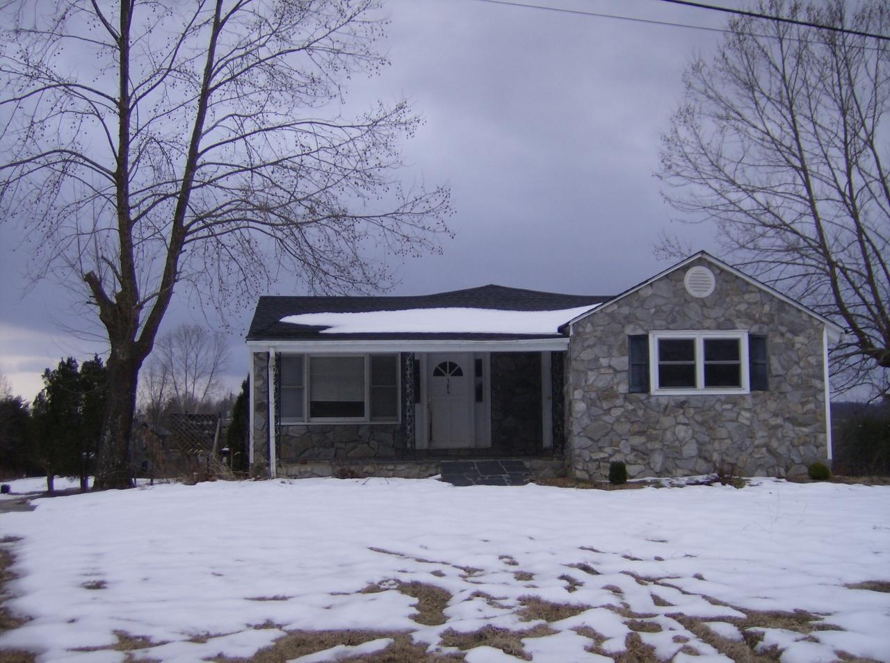 a front view of a house with a yard covered in snow