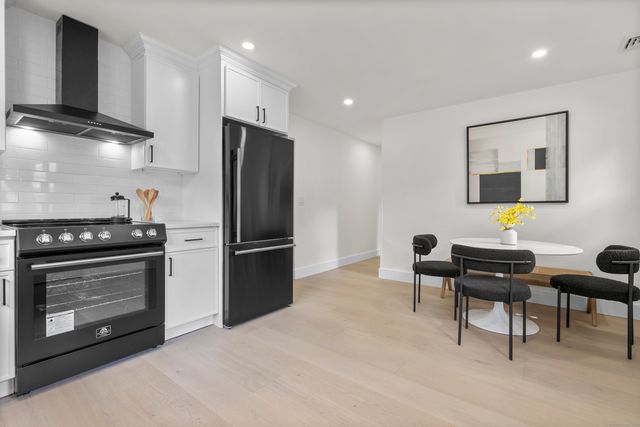 a kitchen with stainless steel appliances kitchen island granite countertop a refrigerator and a stove top oven