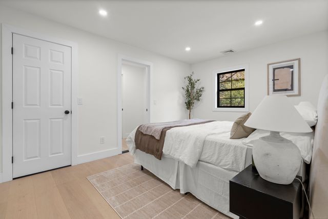 a bedroom with a bed and a painting on the wall