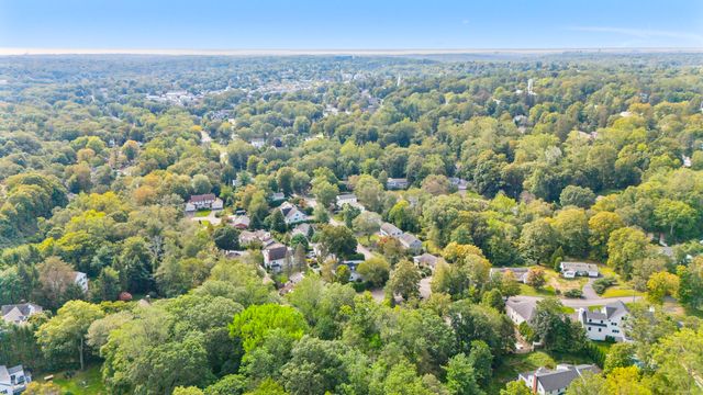 an aerial view of a house with a yard and large trees