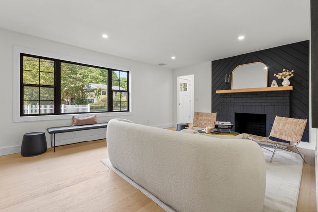 a living room with furniture a large window and a fireplace
